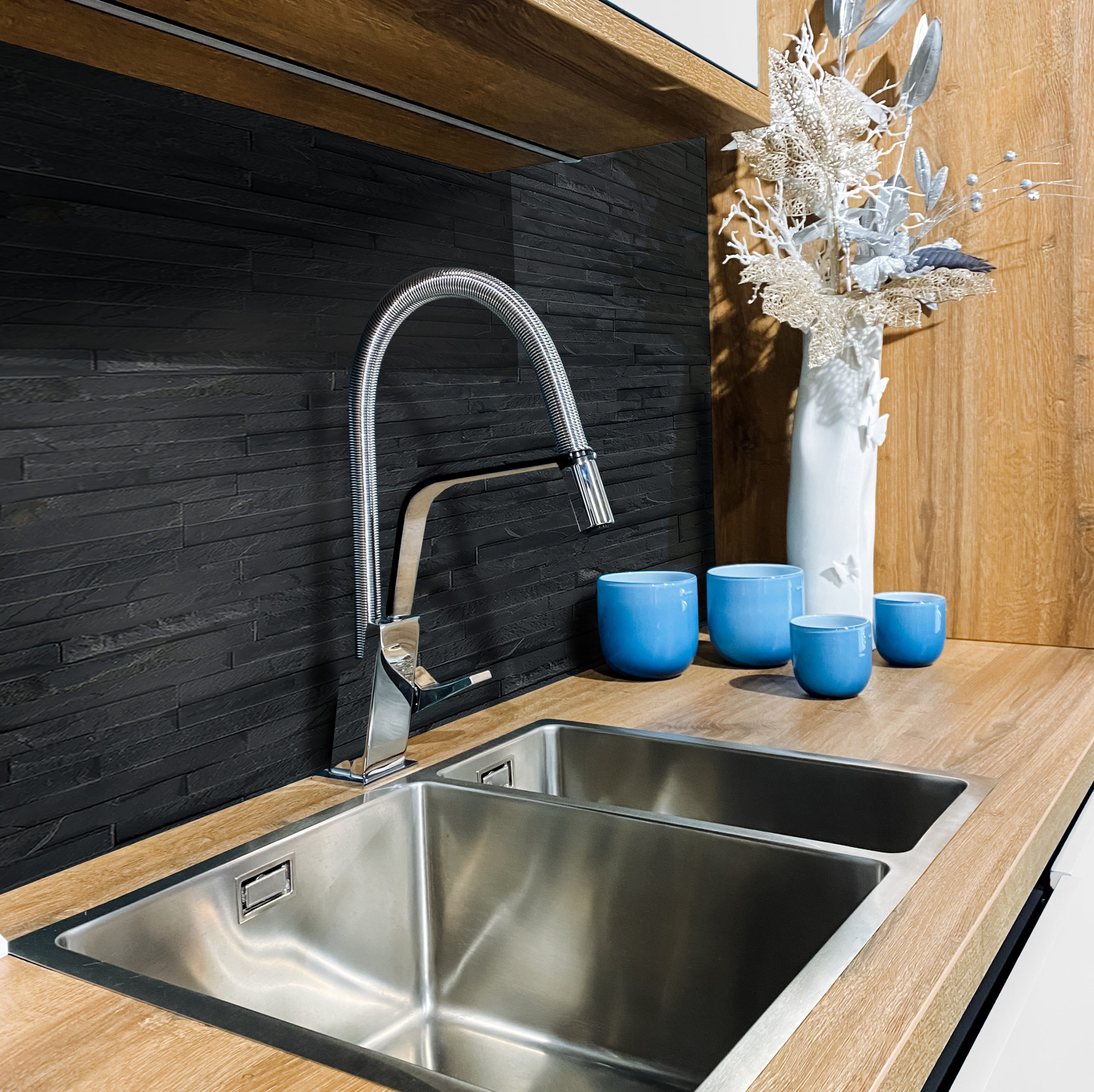 In a welldesigned kitchen, you will find a stainless steel sink elegantly placed on a beautifully crafted wooden counter, creating a perfect blend of functionality and aesthetics