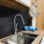 In a welldesigned kitchen, you will find a stainless steel sink elegantly placed on a beautifully crafted wooden counter, creating a perfect blend of functionality and aesthetics
