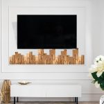 Living room interior with marble side table, tv stand and wall with classic element decoration. Modern furniture and lcd panel at apartment. Home decor idea